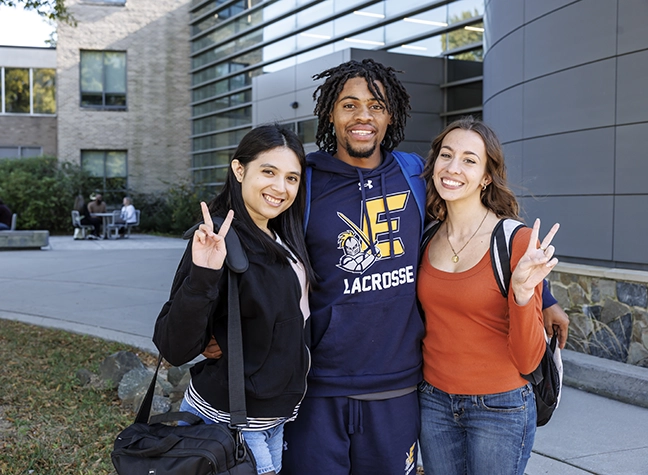 Two female students sitting outside laughing
