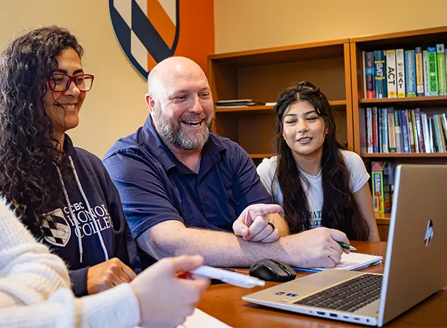 Group of students gathered around a laptop